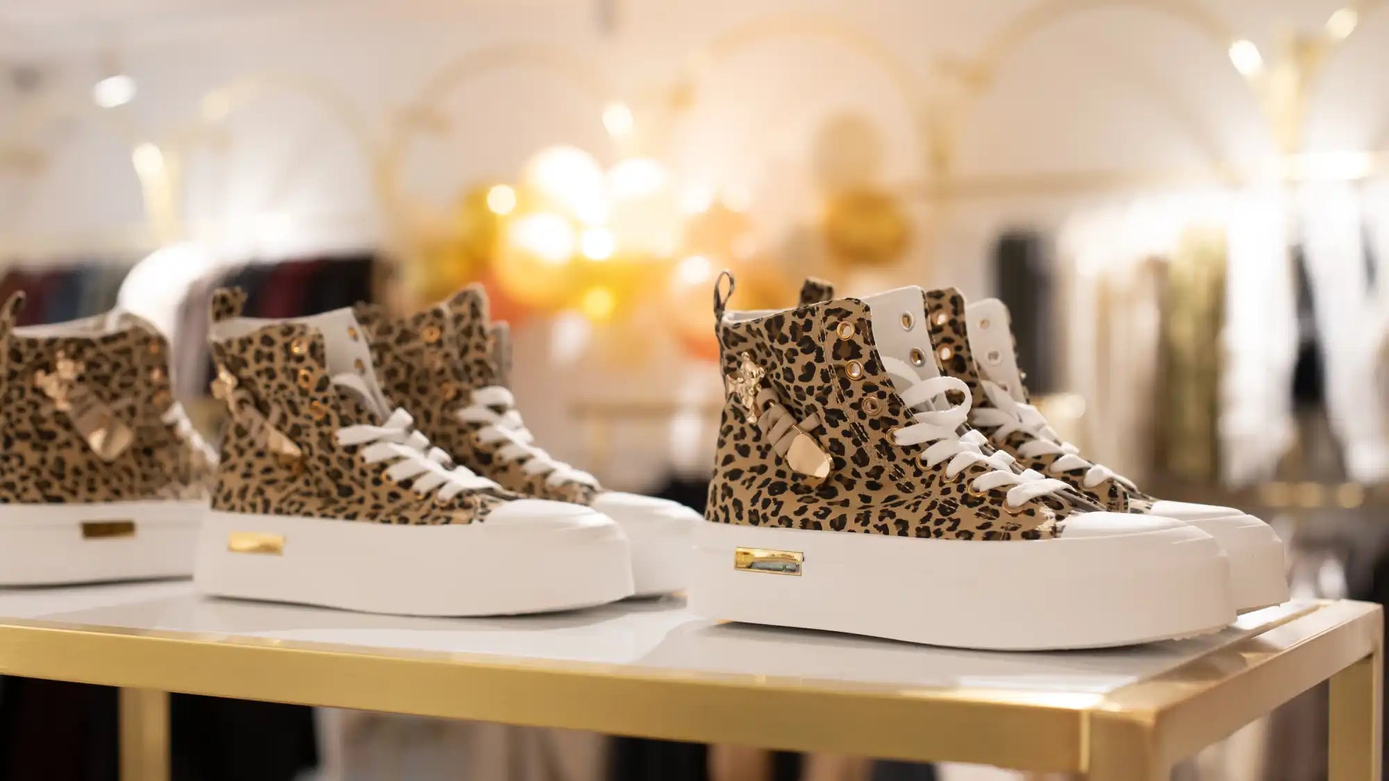 Leopardenmuster-High-Top-Sneaker mit weißen Akzenten und goldenen Logos.