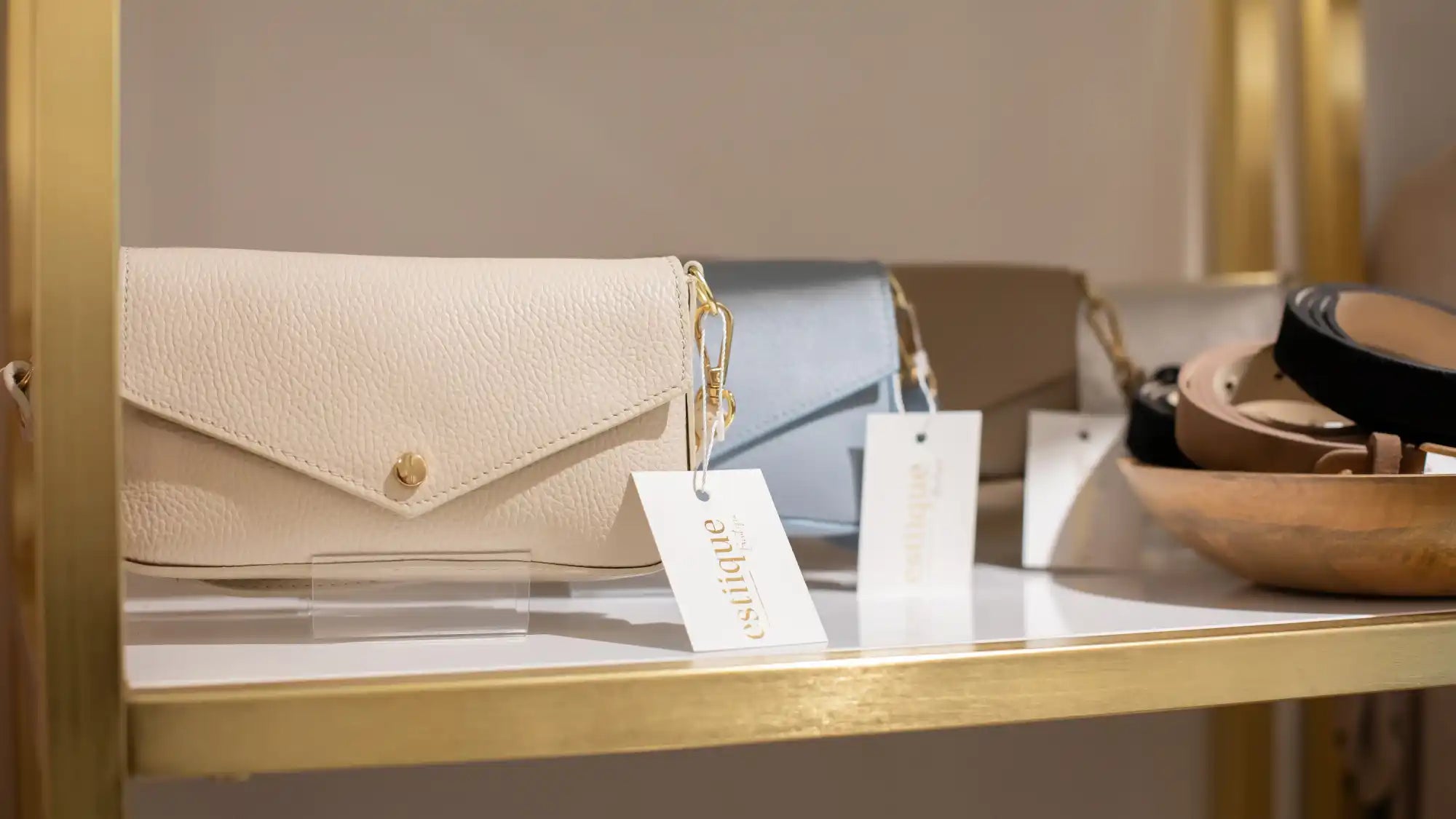 Creme-farbene, texturierte Ledertasche mit goldenem Beschlag und Kettenriemen.